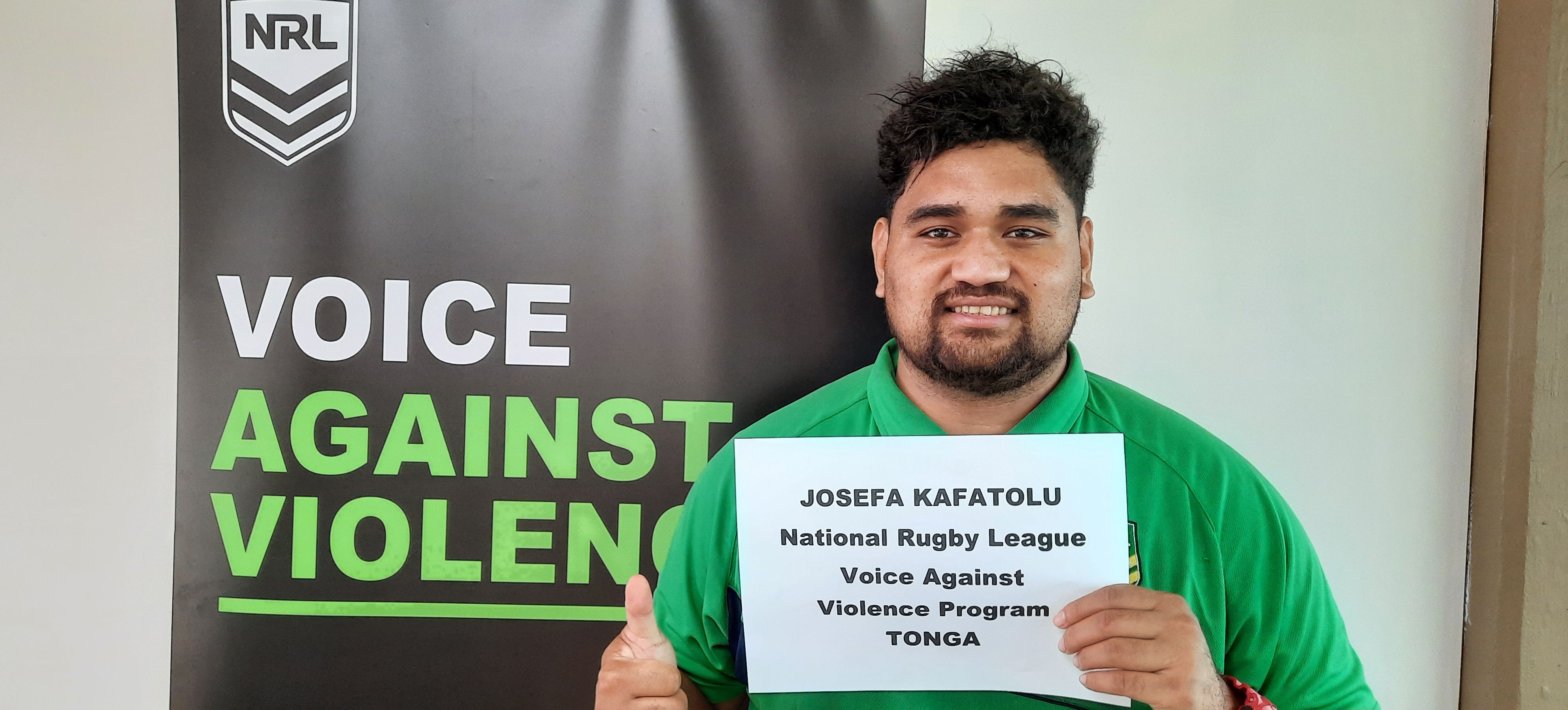 Man in Tonga holding a sign showing his name and job title